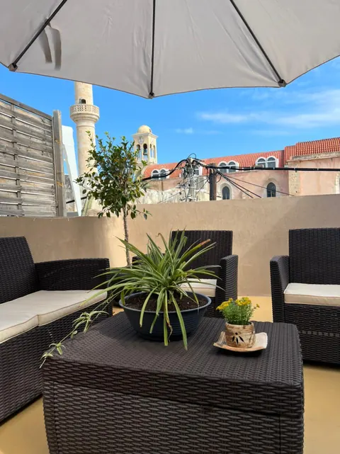 Terrazza: tavolino e poltrone, vista su minareto, campanile e tetti