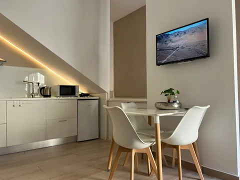 Soggiorno: angolo pranzo, TV a schermo piatto e cucina con luce LED