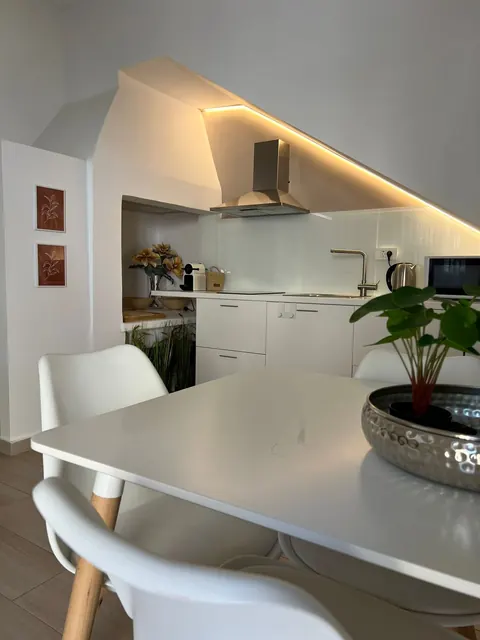 Cucina: tavolo bianco con sedie e cucina sullo sfondo