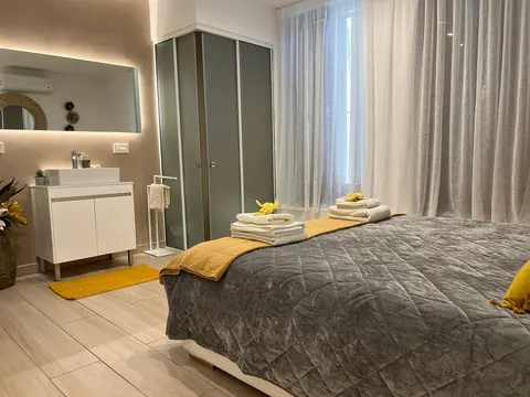 Camera: letto matrimoniale, tende e zona bagno con doccia e lavabo