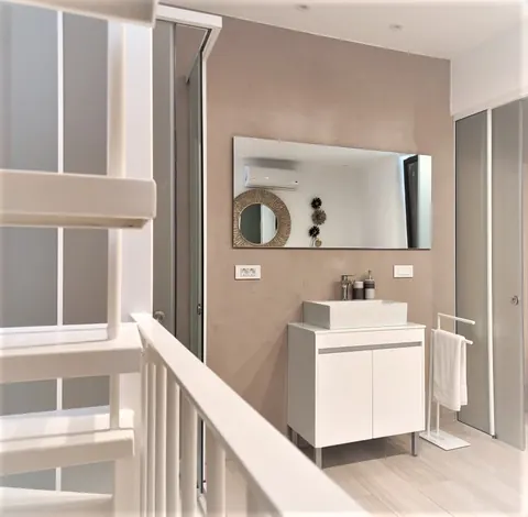 Bagno visto dalla scala: lavabo, specchio e porta-asciugamani