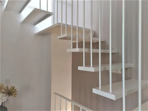 Scala sospesa bianca con ringhiera