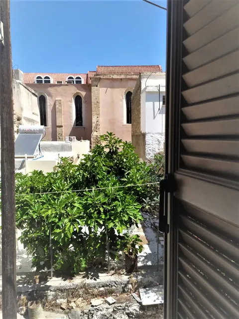 Vista dalla finestra: giardino e chiesa in pietra con finestre ad arco